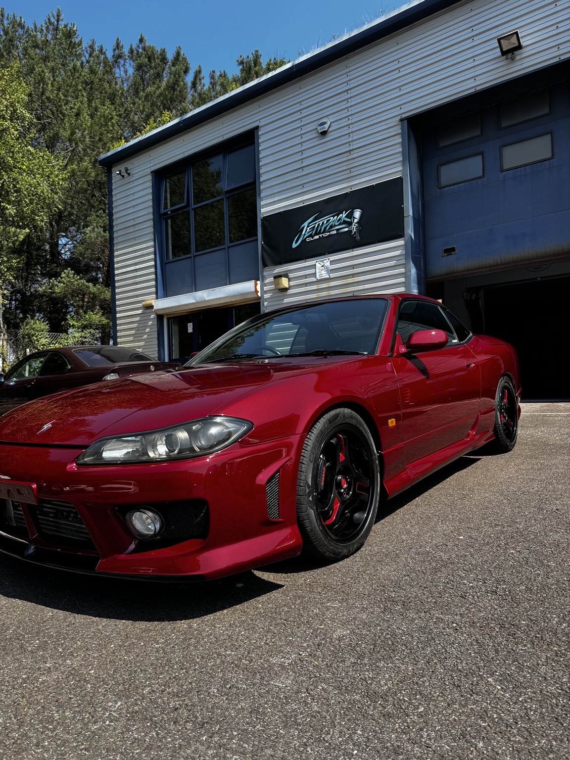 Finished red sports car outside JettPack Customs