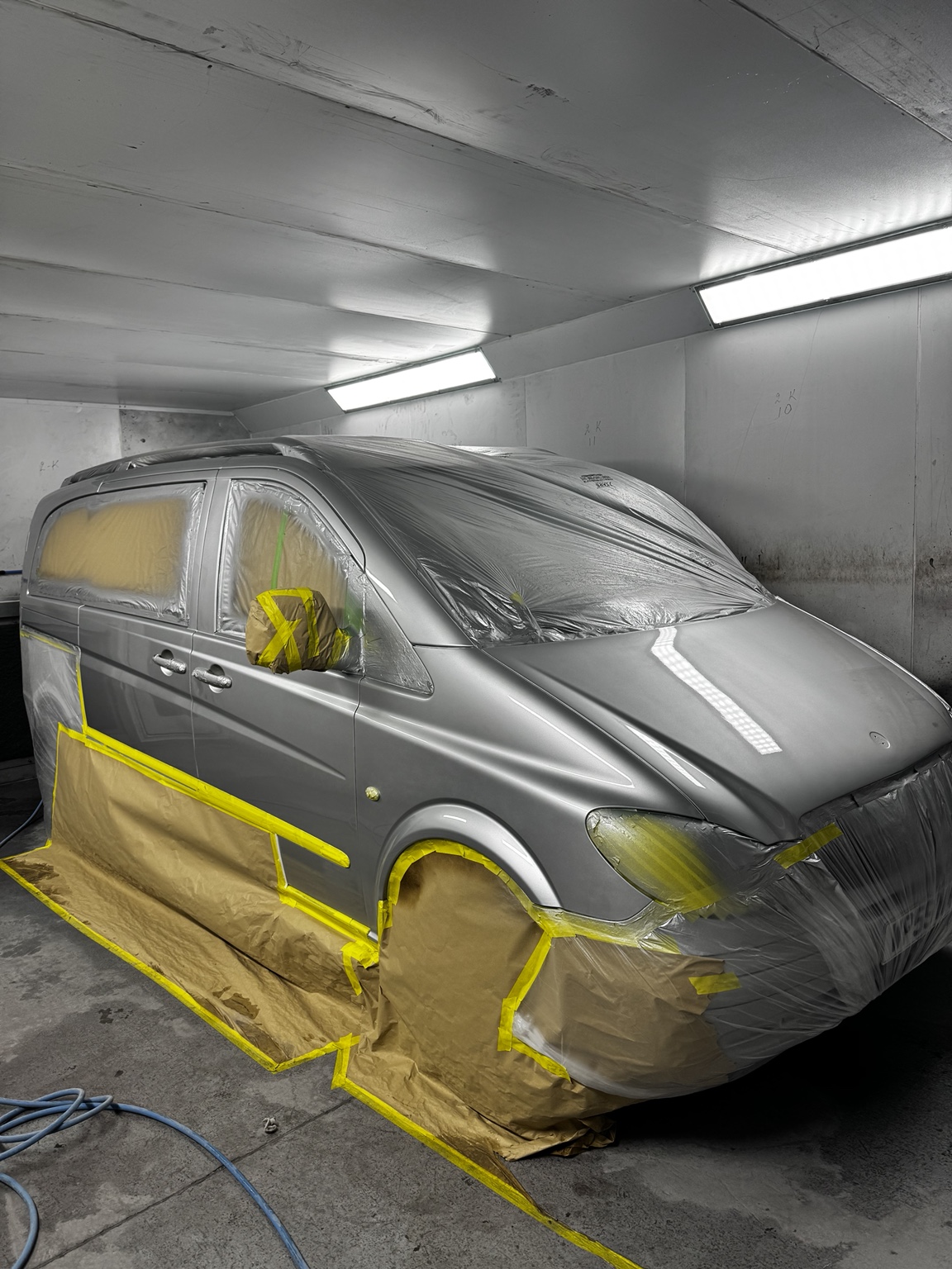 Silver vehicle prepared and refinished in the spray booth