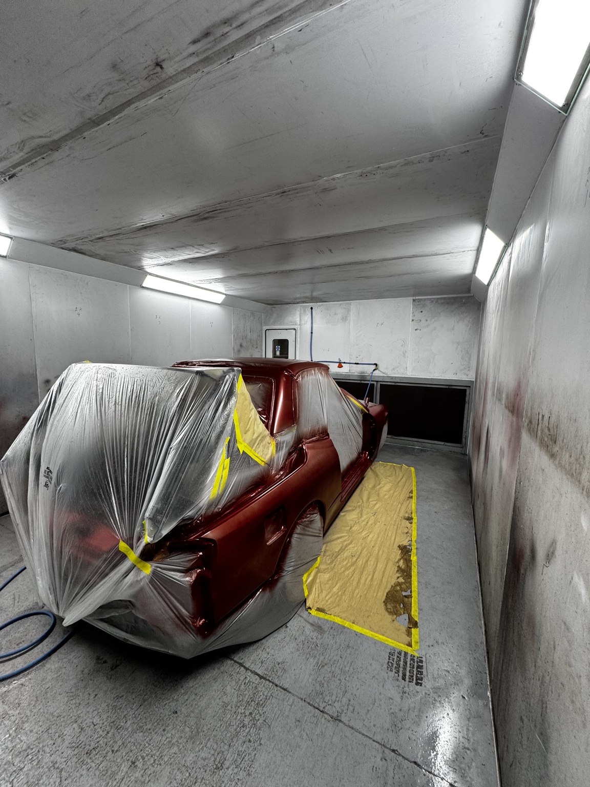 Red vehicle undergoing refinishing